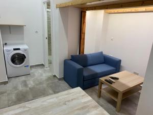 un salon avec une chaise bleue et un lave-linge dans l'établissement Estudio 86, à Torrox Costa