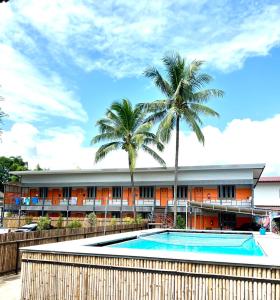 un complejo con piscina y palmeras en Revolution Hostel Pai, en Pai