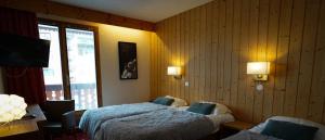 a hotel room with two beds and a window at Hôtel Le Sherpa Val Thorens in Val Thorens