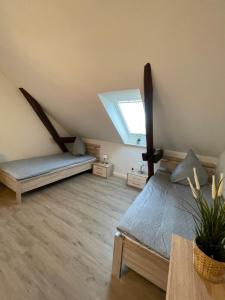 een zolderkamer met een bed en een raam bij Gästehaus Landleben am Deich in Balje