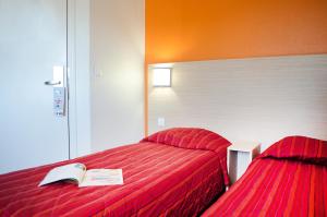 una habitación de hotel con una cama con un libro encima en Hotel HECO Lyon sud Vienne, en Vienne
