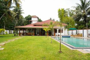 a house with a swimming pool next to a resort at Cozy Villa in Hikkaduwa