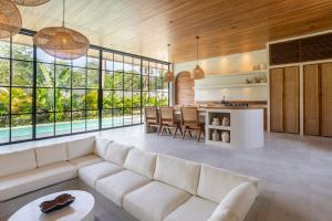 a living room with a white couch and a table at The Dreamland by The Young Villas in Uluwatu