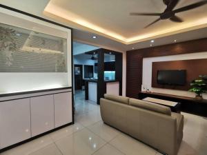 uma sala de estar com um sofá e uma televisão de ecrã plano em Permas 14min to MidValley 10pax WiFi TV Box 4BRoom em Johor Bahru