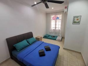 um quarto com uma cama azul e uma ventoinha de tecto em Permas 14min to MidValley 10pax WiFi TV Box 4BRoom em Johor Bahru