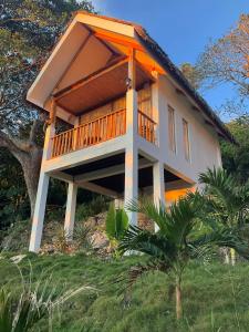 a house with a large deck on a hill at MHARI Bungalows & Studio Rooms in Tubod