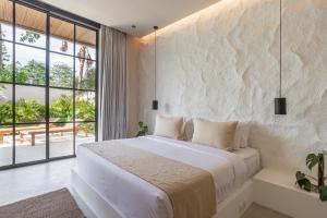 a bedroom with a large bed and a large window at The Dreamland by The Young Villas in Uluwatu +248 photos