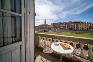 einen Balkon mit einem Tisch und einem Kuchen darauf in der Unterkunft Royal Victoria Hotel in Pisa