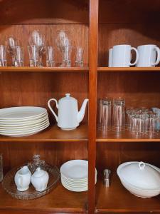 einem Schrank mit Tellern, Tassen und Geschirr in der Unterkunft Apartamento en Primer Piso a 7 min del Centro Histórico in Trujillo