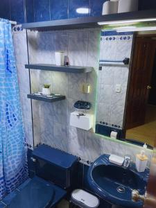 ein Badezimmer mit einem blauen Waschbecken und einer Toilette in der Unterkunft Apartamento en Primer Piso a 7 min del Centro Histórico in Trujillo + 27 Fotos