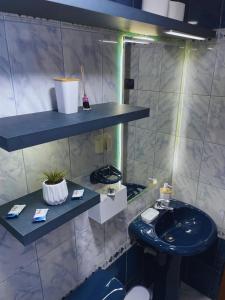 ein Badezimmer mit einem Waschbecken, einem WC und Regalen in der Unterkunft Apartamento en Primer Piso a 7 min del Centro Histórico in Trujillo