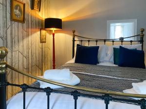 a bedroom with a bed with blue and white pillows at The Stables in Waltham on the Wolds