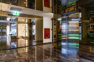 a lobby of a building with a glass elevator at Frame Hotel Bangkok in Bangkok