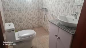 bagno con servizi igienici bianchi e lavandino di Room in Guest room - Charming Room in Kayove, Rwanda - Your Perfect Getaway 
