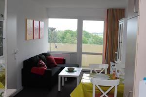 ein Wohnzimmer mit einem Sofa, einem Tisch und einem Fenster in der Unterkunft Ferienwohnung E510 für 2-4 Personen an der Ostsee in Brasilien