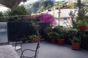 un patio con tavolo, sedie e piante in vaso di Condominio Marina a Rapallo