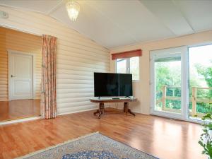 uma sala de estar com uma televisão de ecrã plano e uma mesa em 2 The Follys - Uk45188 em Abbotskerswell