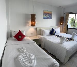2 camas en una habitación con paredes blancas en Istanbul Boutique Hotel en Patong Beach