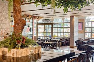 a restaurant with tables and chairs and a tree in a trunk at Frame Hotel Bangkok in Bangkok