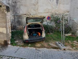 un pequeño coche con el baúl abierto sentado junto a una pared en T2 Autonome, centre ville proche Cathédrale en Toul