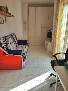 ein Wohnzimmer mit einem Sofa und einem Tisch in der Unterkunft Casa al mare con giardino vicino a Roma in Torvaianica