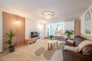 a living room with a couch and a tv at Idéal Famille: Jardin, Proche Commerces & Plage in Bray-Dunes