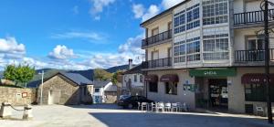 a building with a car parked in a parking lot at Pensión Río Cenza in Villarino de Conso