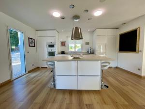 a kitchen with white cabinets and a large island at Villa Grey - Brignoles - Provence verte in Brignoles