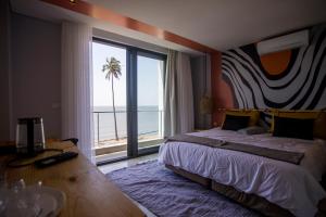 a bedroom with a large bed and a large window at Cowork Lab Suites in Maputo