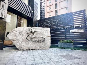 uma rocha com um veado em frente a um edifício em Vasty Jiaoxi Hotel em Jiaoxi