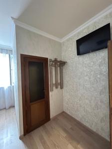 Zimmer mit einer Tür und einem TV an der Wand in der Unterkunft SoSe in Vaykʼ