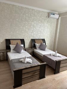 una camera d'albergo con due letti con scarpe sopra di SoSe a Vaykʼ