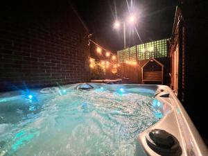 a jacuzzi tub in a backyard at night at Station House-Hinton Admiral in Christchurch
