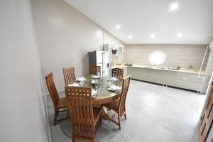 uma cozinha com uma mesa com cadeiras e um frigorífico em Karucoco Lodge em Sainte-Anne