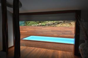 a swimming pool viewed through a glass door at Karucoco Lodge in Sainte-Anne