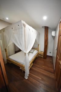 Karucoco Lodge في ساينت آن: غرفة نوم بسرير مع ناموسية