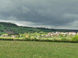 a village in the hills with a green field at A Bird House in Belper +32 photos
