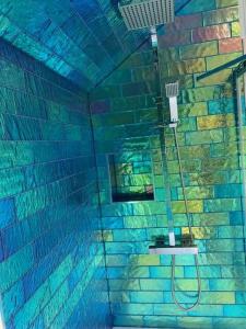 a bathroom with a shower in a brick wall at A Bird House in Belper