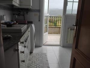 eine Küche mit einer Tür, die auf einen Balkon führt in der Unterkunft Tranquilidad y Naturaleza in Mondariz-Balneario