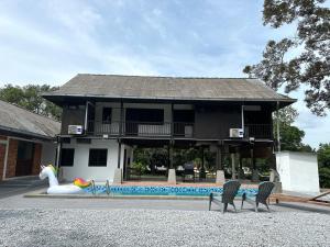 una casa con piscina e un cigno di fronte ad essa di The Wooden Retreat by Elite Stay a Port Dickson