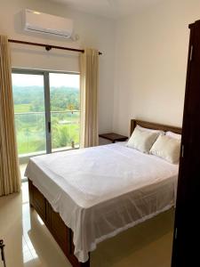 um quarto com uma cama e uma grande janela em Golfers' Paradise Kahathuduwa em Gonapola