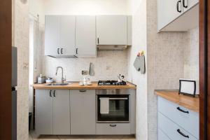 uma pequena cozinha com armários brancos e um lavatório em Stylish & Cozy - 5 Star Location- Balcony - City View em Roma