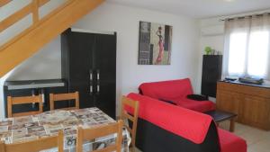 a living room with a red couch and a chair at Jason in Cervione
