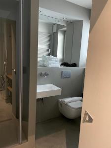 a bathroom with a toilet and a sink and a mirror at Hotel Mons am Goetheplatz in Munich