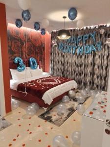 Ajilin Hotel Rooms في كورتشي: غرفة نوم مع سرير مع علامة عيد ميلاد سعيد