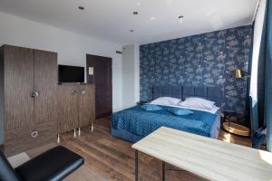 チェンストホヴァにあるApartamenty Komfortのベッドルーム(青いベッド1台、テレビ付)