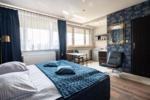 1 dormitorio con cama, escritorio y cocina en Apartamenty Komfort, en Częstochowa