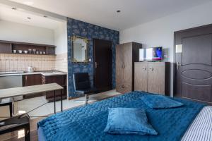 チェンストホヴァにあるApartamenty Komfortのベッドルーム(青いベッド1台付)、キッチン