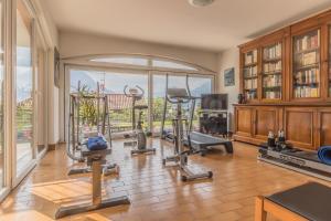 Un gimnasio con máquinas de ejercicio y una gran ventana. en Candy House, en Varenna
