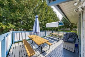 una terraza con mesa, sombrilla y banco en Beautiful Comfy & Relaxed Basement Room - Great Location C4 en Surrey